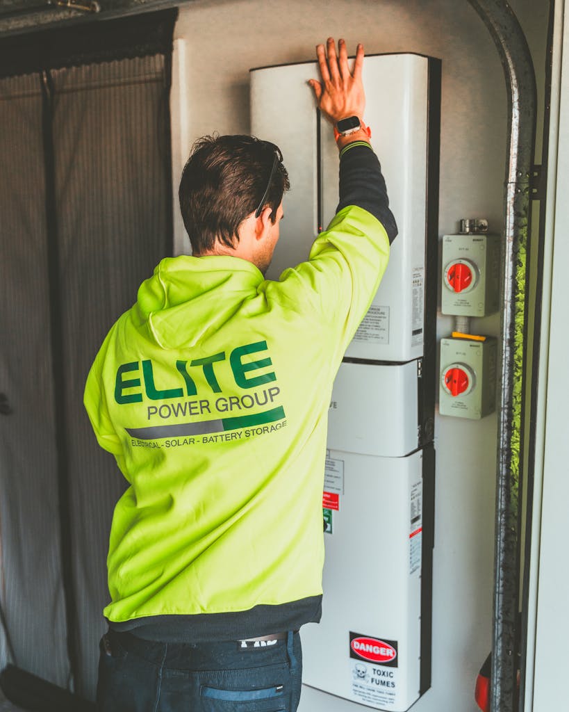 Technician installing a solar inverter and battery system in New South Wales.